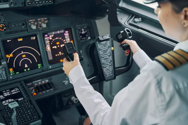 Professionell kvinnlig pilot navigerar ett flygplan — Stockfoto