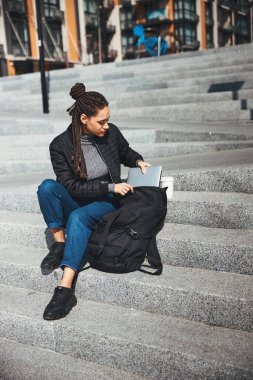 Ciddi kadın serbest çalışan, aletine uzanıyor.