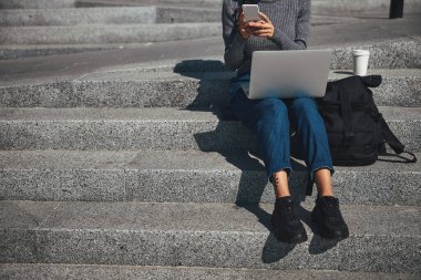 Örgülü bir kadın cep telefonuna mesaj yazıyor.