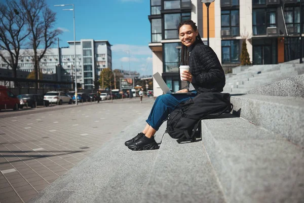 Glada dam med en bärbar dator sittande utanför — Stockfoto