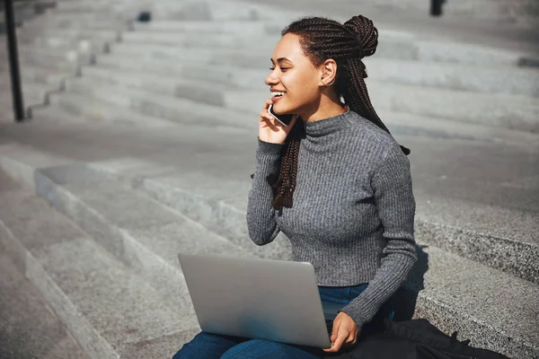 Sorrindo senhora alegre com cornrows chamando no smartphone — Fotografia de Stock