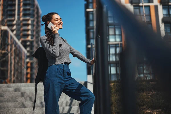 Glädjande kvinna talar på smartphone i en betongtrappa — Stockfoto