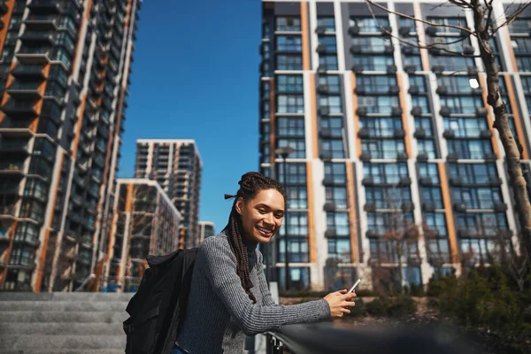 Jolly turist med en ryggsäck och en smartphone ser framåt — Stockfoto