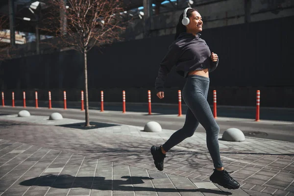 Alegre deportista guapa vestida con ropa deportiva corriendo por la mañana — Foto de Stock