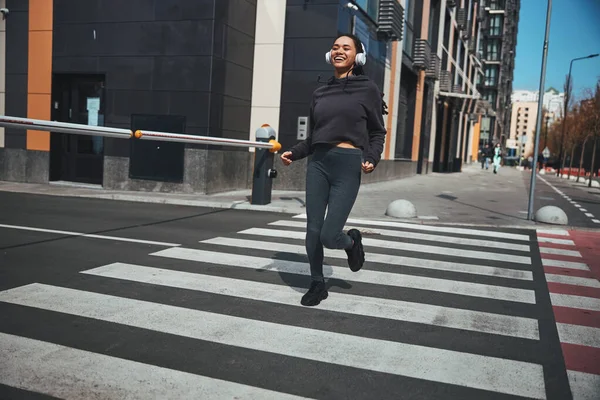 Glada sportig dam joggar i stadens centrum — Stockfoto