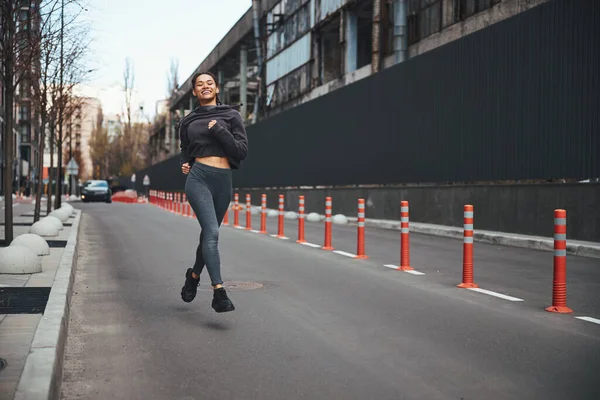 Souriant fit lady jogging dans le centre-ville — Photo