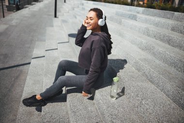 Kablosuz kulaklıklı mutlu bayan en sevdiği müziğin tadını çıkarıyor.