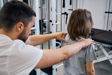 Masaj terapisti, tedavi merkezindeki kızı tedavi ediyor. Kayropraktik uzmanı omurgayı ve boynu kontrol ediyor.
