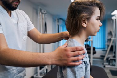 Profesyonel manuel terapist, masaj yatağında küçük kızların boynunu tedavi ediyor. Osteopat-masör