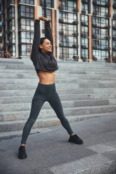 Радісна жінка-спортсменка робить розтяжку вправи — стокове фото