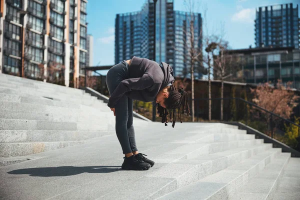 Woman with cornrows doing an exercise for stretching hamstrings and calves — 图库照片