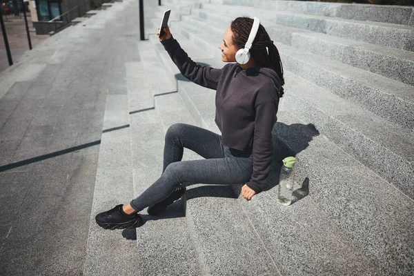 Radostná žena bere selfie na betonové schody — Stock fotografie