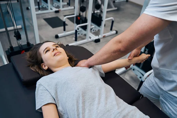 Dívka dostane chiropraktickou terapii ramen od muže fyzioterapeut ve sportovní zranění rehabilitační — Stock fotografie