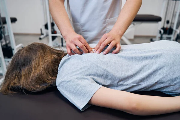 Physiotherapist checks girl with spine deformity at session in rehabilitation room. Manual therapist — 图库照片