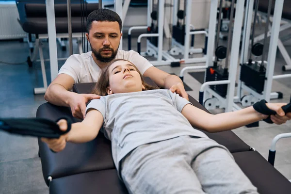 Girl exercising on decompression simulators with physiotherapist help in rehabilitation center — Foto de Stock