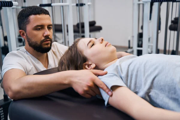 Close up kinderfysiotherapeut behandelt jong meisje op revalidatie decompressie machines — Stockfoto