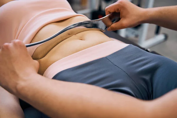 Close up chiropractic massage with IASTM tool in rehabilitation clinic. Physiotherapist treats female — стоковое фото