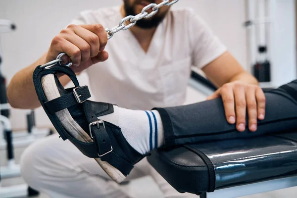 Detailní fyzioterapeut cvičení mladá žena s rehabilitační obuv pěšky na elastické pevnostní simulátor — Stock fotografie