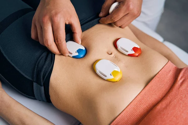 Close up of electrostimulators on woman abdomen. Myostimulation electrodes. Electric stimulators — Stockfoto