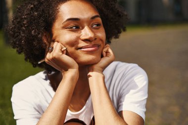 Dreamy lady sitting outdoors and looking away