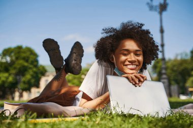 Beautiful young lady looking happy outdoors with gadget