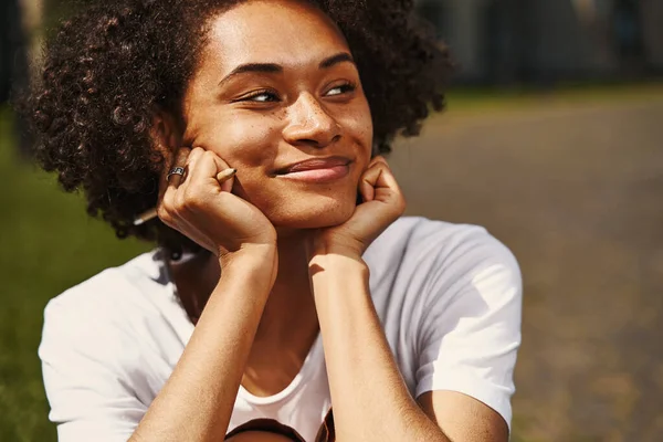 Dreamy lady sitting outdoors and looking away — Stock Photo, Image