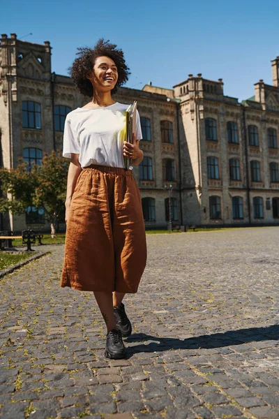 Contented excellent student walking from the university —  Fotos de Stock