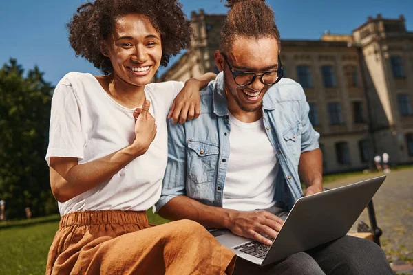 Delighted young couple using modern gadget outdoors —  Fotos de Stock