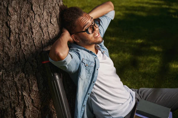 Relaxed young man in casual clothes sitting outdoors — Stockfoto