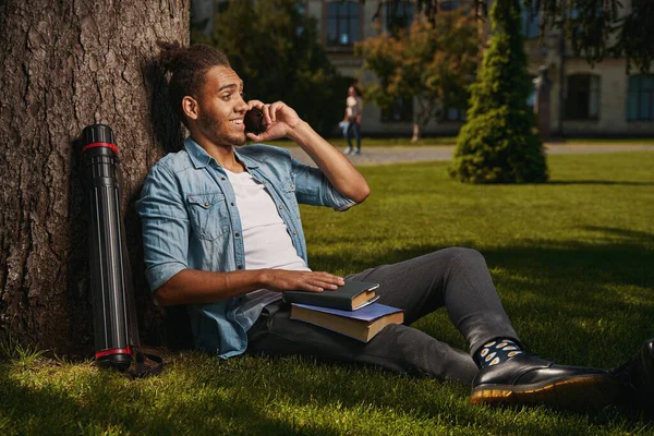 Mirthful student getting pleasant phone call while being outdoors — Photo