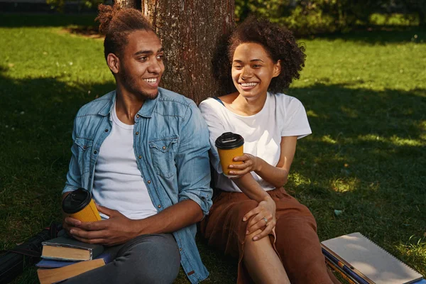 Gladsome couple chilling under the tree on sunny day — 스톡 사진