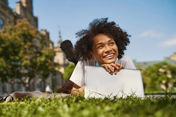 Dreamy young lady relaxing with laptop outdoors — ストック写真