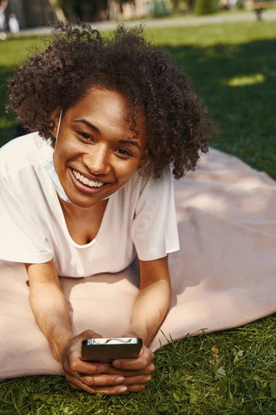 Contented young woman having pleasant time in the park — Photo