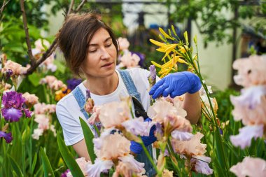 Cute female person looking after yard in gloves