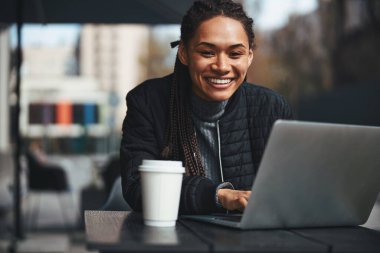 Happy lady with modern gadget sitting outdoors