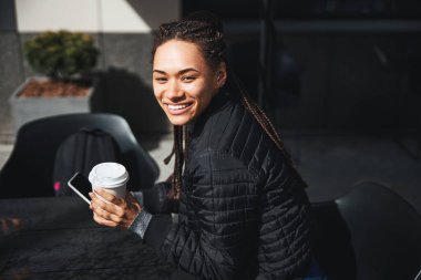 Sunny day outdoors with smartphone and tasty beverage