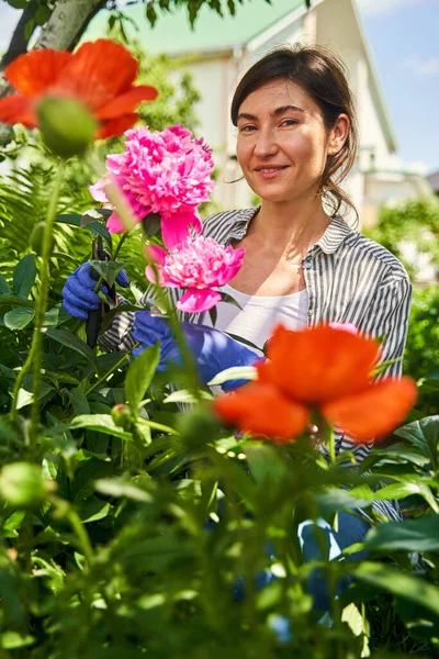 Pessoa feminina desfrutando cheiro de flores floridas — Fotografia de Stock