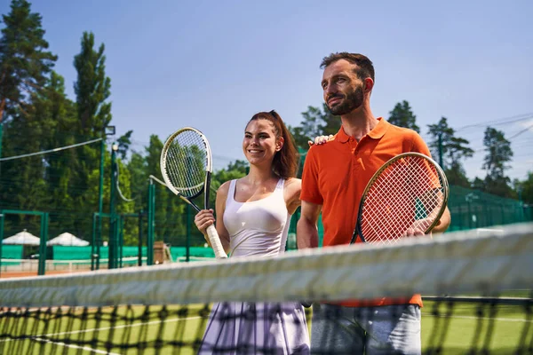 Dois jovens desportivos com raquetes olhando para a distância — Fotografia de Stock