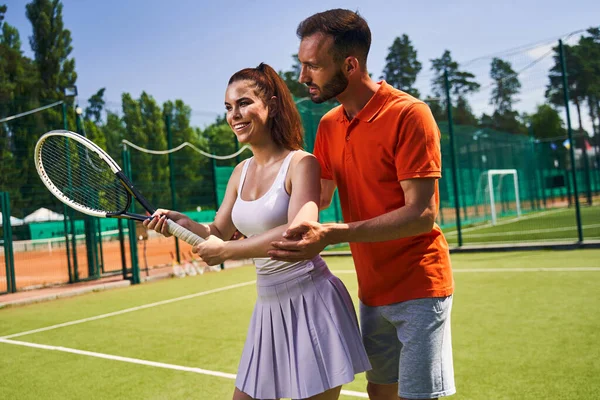 Souriant débutant prenant un cours de tennis privé — Photo
