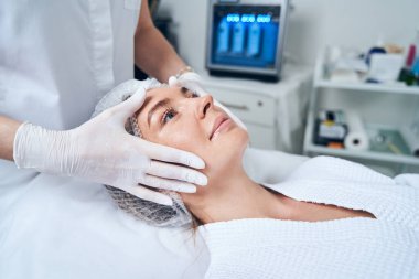 Prosedür sırasında koltukta uzanan mutlu kadın.