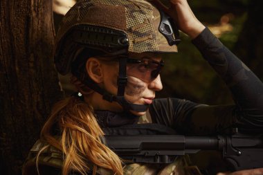 Ormanda silah kullanan kasklı güzel bir kadın.