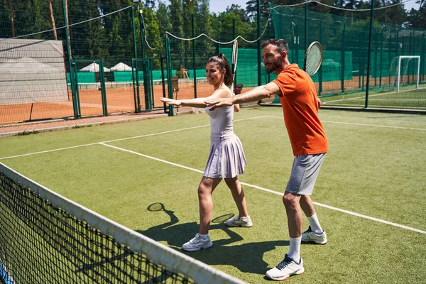 Cliente do sexo feminino tendo uma lição de tênis iniciante privado — Fotografia de Stock