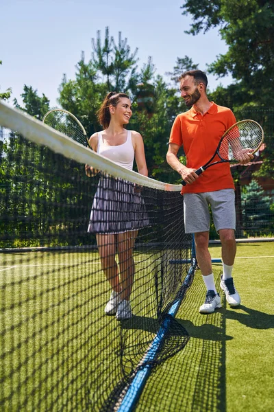 Dois desportistas sorridentes com raquetes a olhar um para o outro — Fotografia de Stock