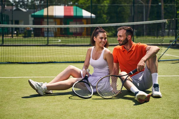 Deux partenaires de tennis assis sur l'herbe — Photo