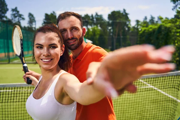 Freudige attraktive Spielerin, die die Aufschlagtechnik lernt — Stockfoto