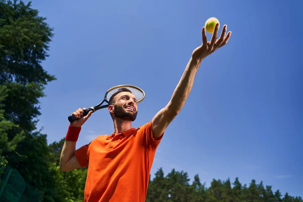 Male tennis player tossing the ball into the air — Stock Photo, Image