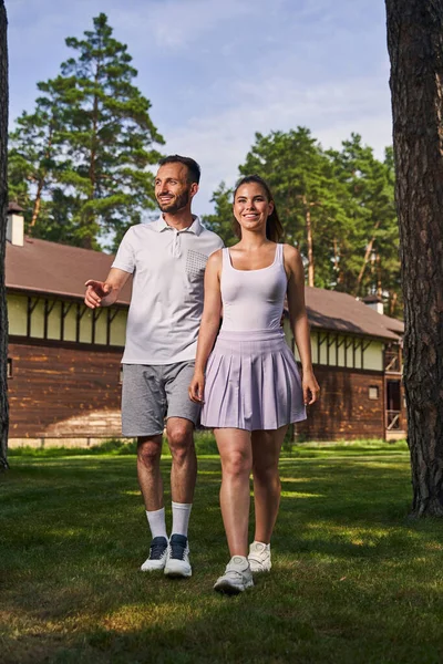 Atraente jovem casal vestido com roupas casuais indo em frente — Fotografia de Stock