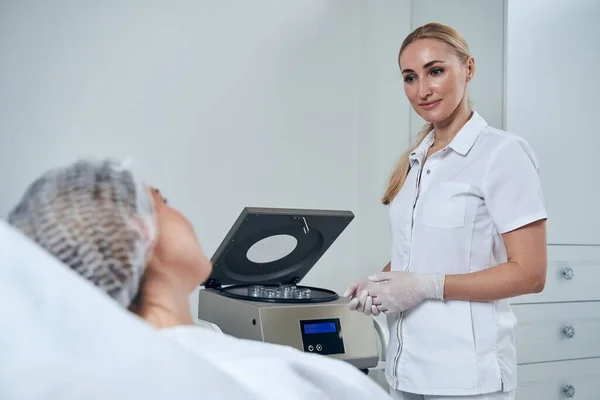 Young serious medical worker standing near sterilizer — Stockfoto