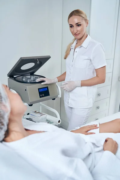 Competente cosmetoloog in gesprek met haar vrouwelijke patiënt — Stockfoto