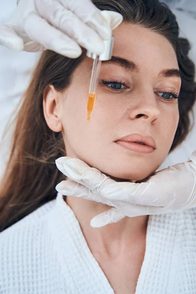 Young brunette woman taking care of her face — Stockfoto